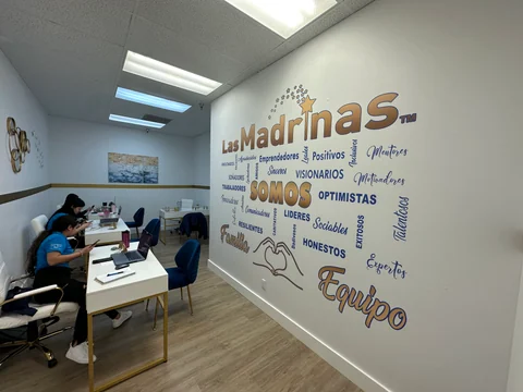Office area with workstations and a wall of lettering and illustrations beside the entrance passage.