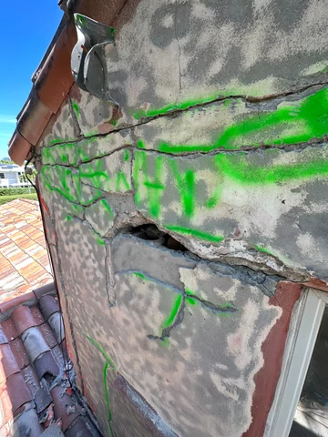 Exterior wall detail with cracks marked in green, an opening and the edge of a window.