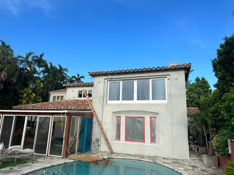 The rear facade beside the pool without the scaffolding seen in the previous photograph, with coverings still on the lower openings.