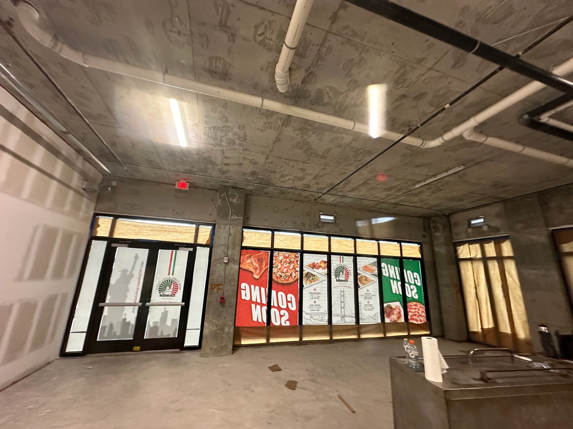Wide view of the Craft interior at the start, with an unfinished floor, exposed services and the glazed entrance in the background.