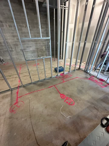 Interior framing with pink layout markings on the floor and openings between rooms.