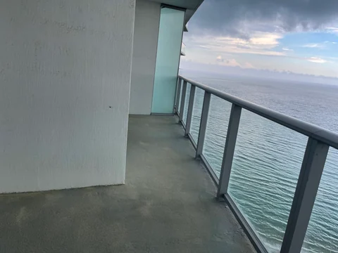 Balcony with an unfinished floor base, glass railing and an open view toward the water.