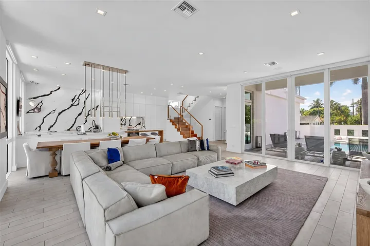 Washington living room with a light sofa, coffee table and large windows, connected to the kitchen and dining area.