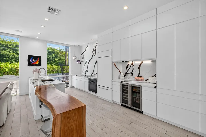 Washington kitchen with white cabinets, black-veined surfaces, an island and a wood breakfast bar.