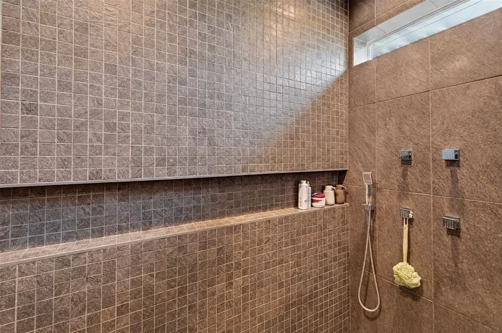 Washington shower with small-format wall tiles, a horizontal niche, a high window and a handheld shower.